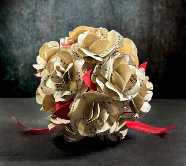 Bouquet sposa carta realizzato con pagine di libri riciclati, ideale per un matrimonio a tema letterario low cost.