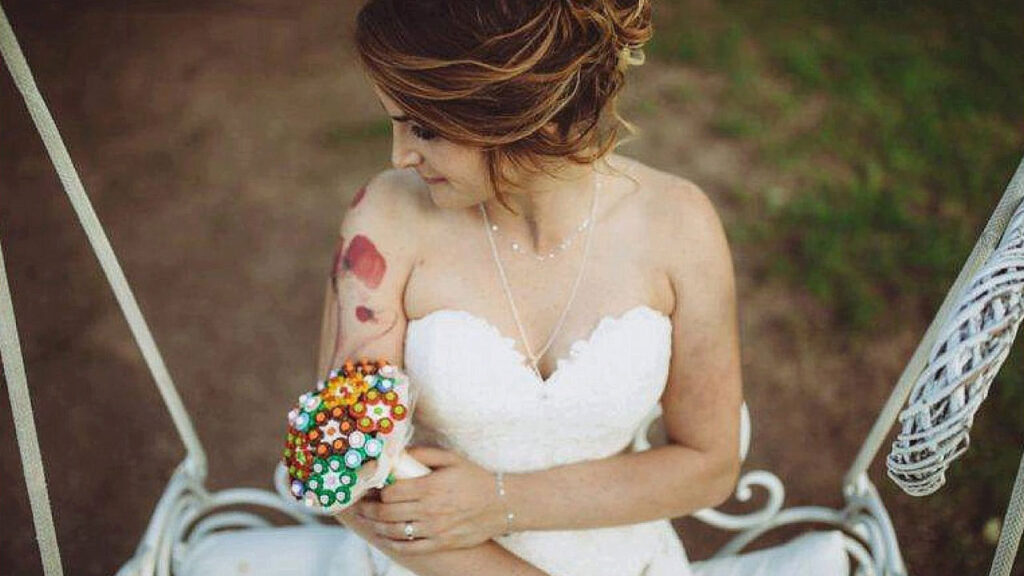 Sposa che stringe tra le mani un bouquet personalizzato con mattoncini LEGO e bottoni argentati, stile geek chic.
