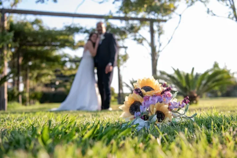 Bouquet sposa originale 2026 con girasoli in seta e fiori di lavanda, realizzato a mano da Jessica Ciaffarini su un prato durante un matrimonio.