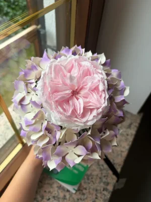 Foto dall'altro del bouquet romantico con ortensie e rosa inglese in carta, fatta dalla cliente a pacco appena arrivato