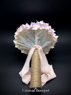 Particolare del sotto calotta e dell'attacco del manico in corda con fiocco di nastro sfrangiato, logo Unusual Bouquet in evidenza.
